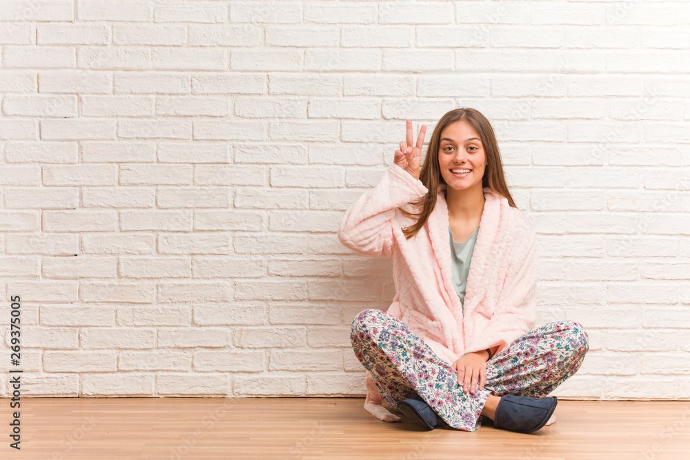 Young woman wearing pajama fun and happy doing a gesture of victory Young woman wearing pajama fun and happy doing a gesture of victory