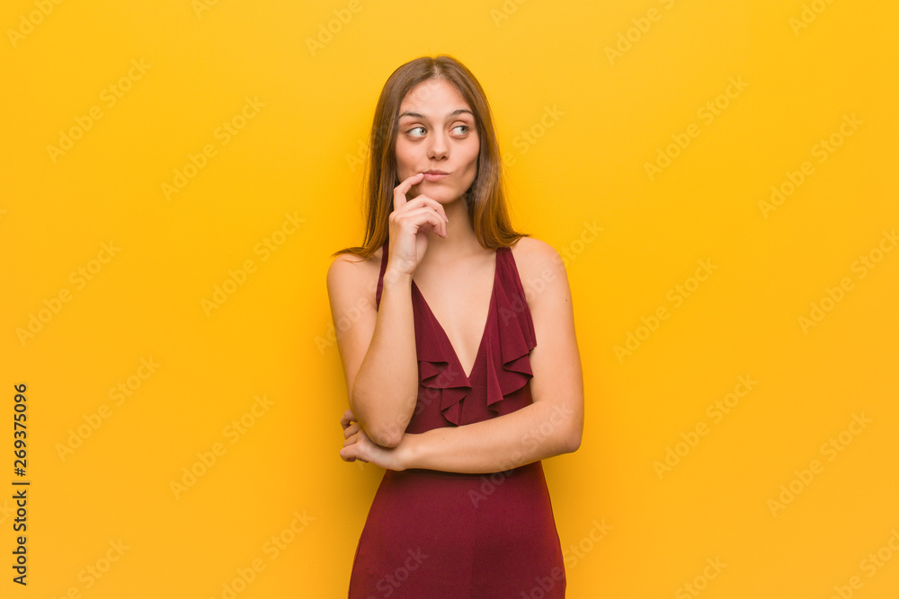 Young elegant woman wearing a dress doubting and confused Young elegant woman wearing a dress doubting and confused
