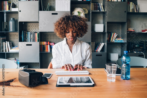 young african businesswoman working with tablet in modern studio photo