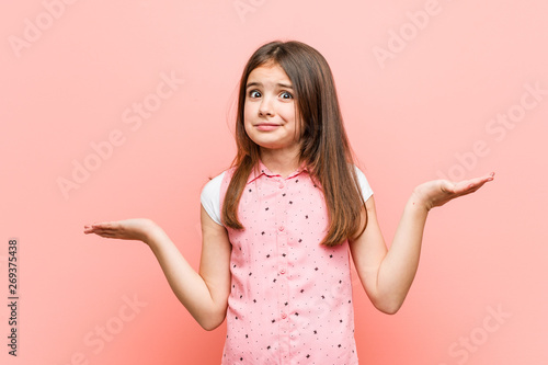 Obraz na płótnie Cute little girl doubting and shrugging him shoulders in questioning gesture