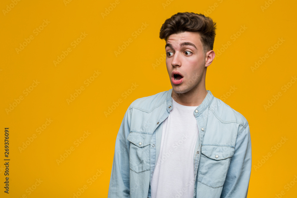 Obraz premium Young handsome student wearing a denim shirt being shocked because of something she has seen.