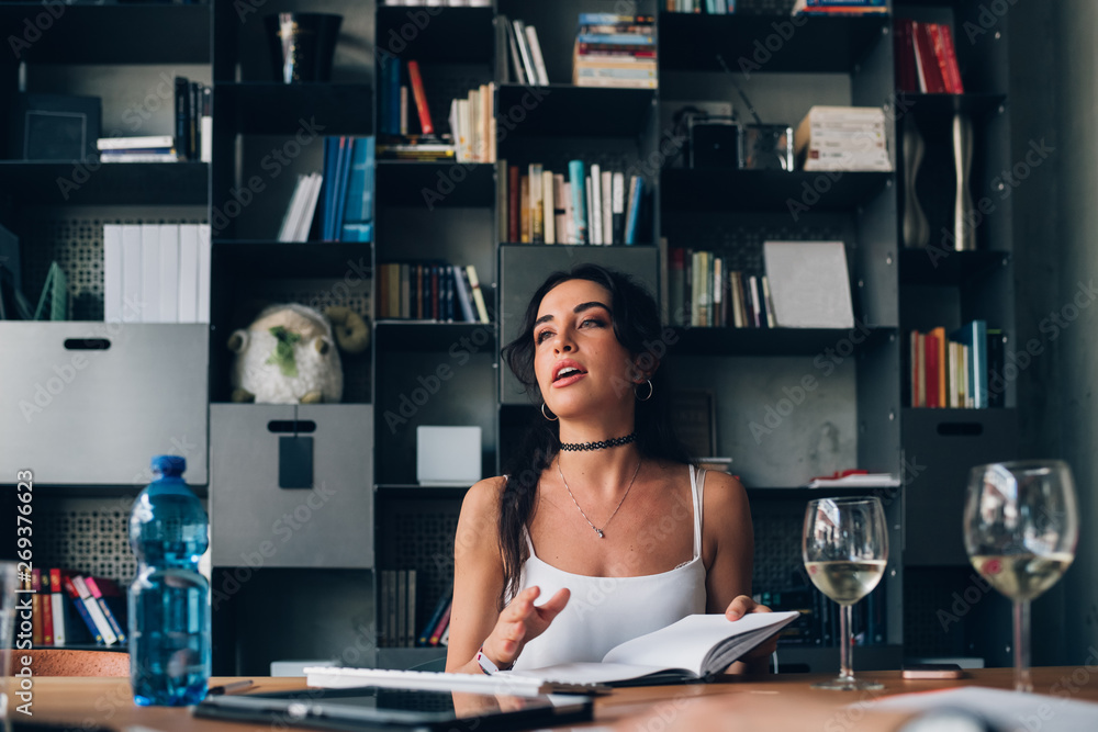 young caucasian woman sitting in modern co-working office and having informal meeting young caucasian woman sitting in modern co-working office and having informal meeting