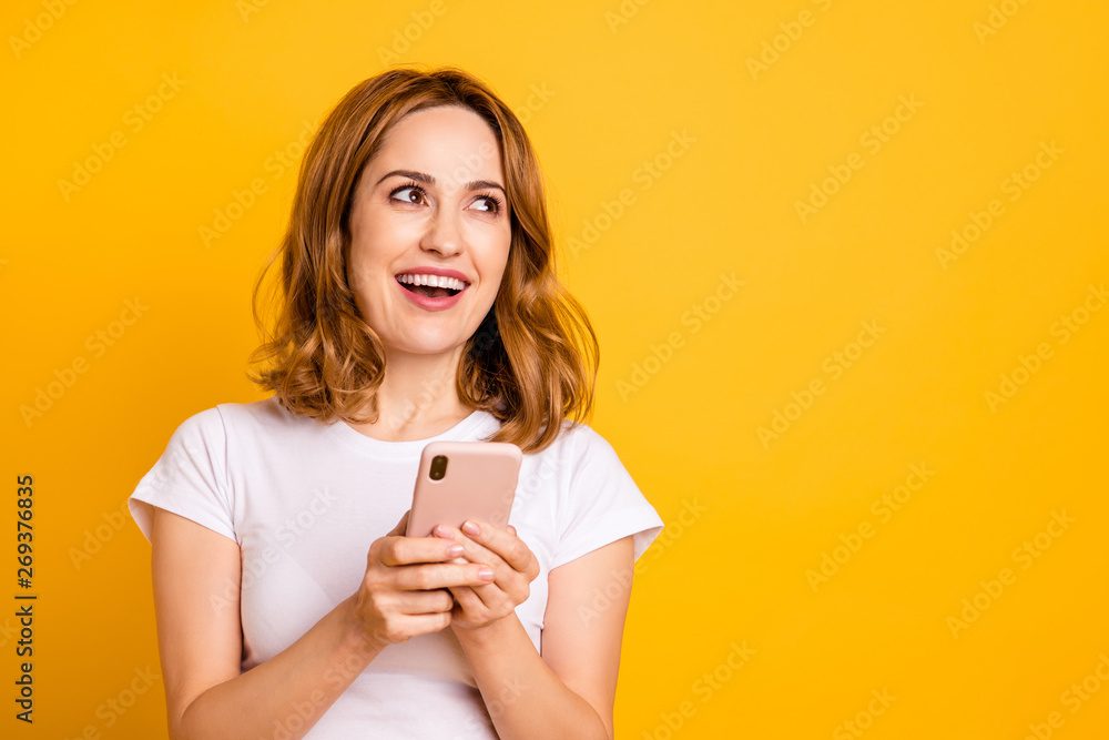 Portrait of nice pretty funky funny millennial hold hand modern technology  use user apps blog blogger think check news feed minded positive cheerful  content dressed t-shirt isolated yellow background Stock Photo |