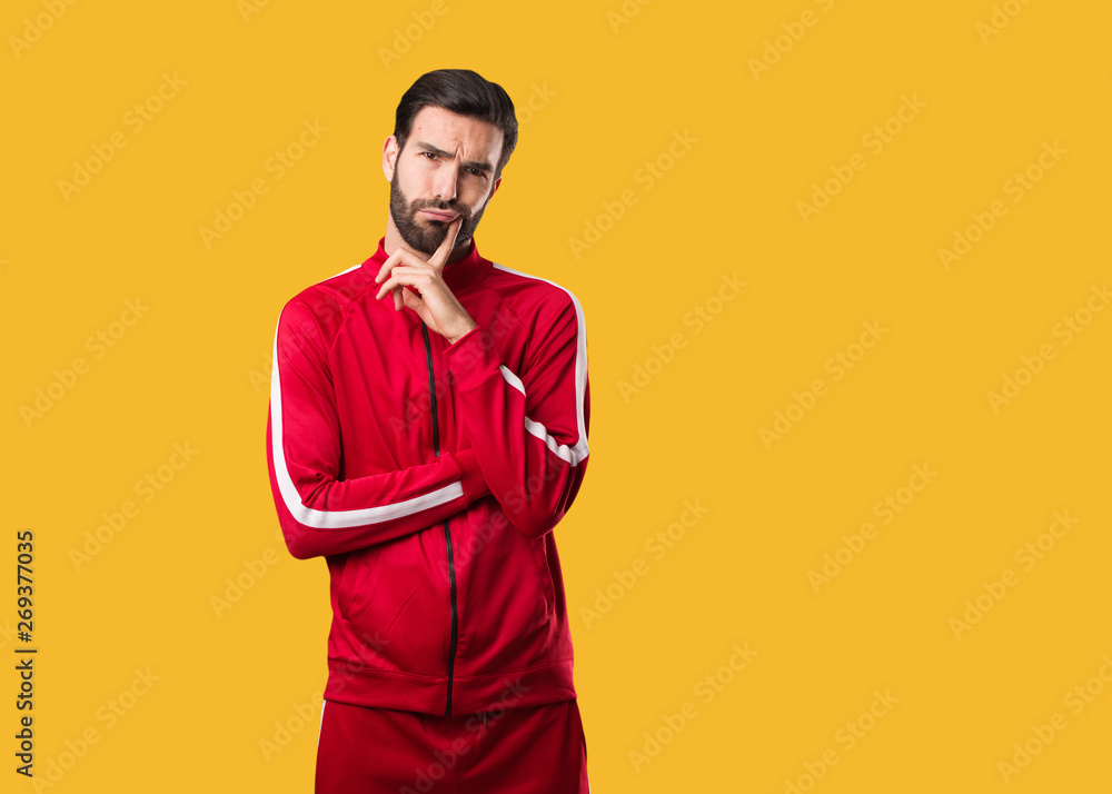 Fototapeta premium Young fitness man doubting and confused