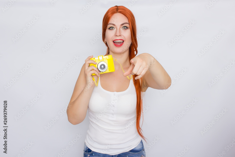 Redhead woman making photot and looking at yellow camera Redhead woman making photot and looking at yellow camera