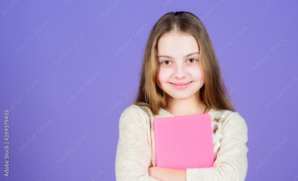 Its her favorite book. Cute small child with text book in hands. Adorable little girl holding exercise book. Self study grammar book, copy space Its her favorite book. Cute small child with text book in hands. Adorable little girl holding exercise book. Self study grammar book, copy space