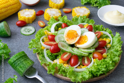 Healthy vegetables salad with boiled egg in wooden dish on table for vegetarian.