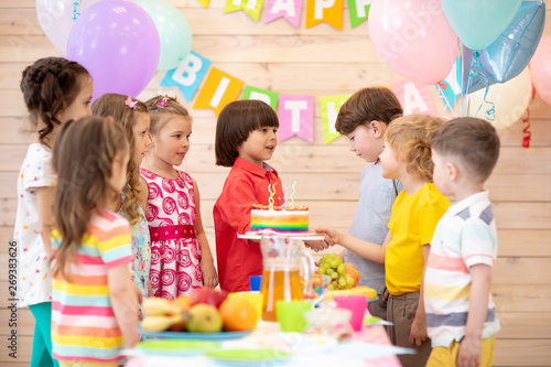 Groups of children come to parties and shake hands with a birthday boy. Cheerful pretty kids have come to congratulate their friend