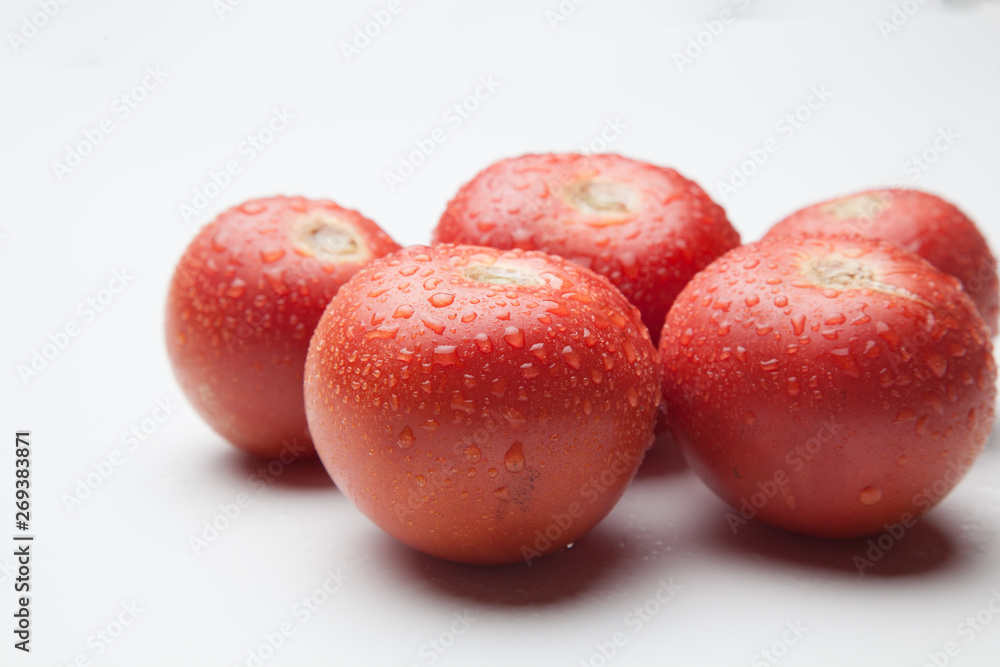 Tomates rojos, sanos y con gotas de agua sobre fondo blanco Tomates rojos, sanos y con gotas de agua sobre fondo blanco