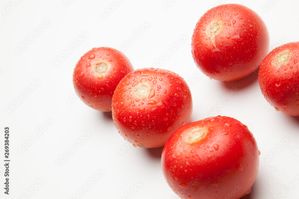 Tomate, rojo, sano con gotas de agua sobre fondo blanco Tomate, rojo, sano con gotas de agua sobre fondo blanco
