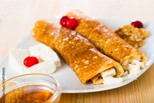 Bulgarian thin pancakes with brynza on white plate photo