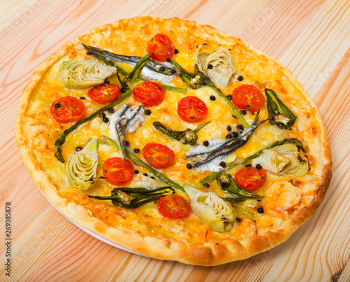 Pizza with anchovies, artichokes, cheese, sun-dried tomatoes