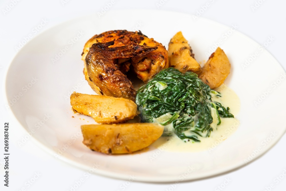 Chicken wing, potato and spinach, isolated on white. Chicken wing, potato and spinach, isolated on white.