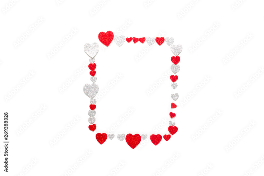 Frame made of different-sized confetti hearts with silver and red sparkles. Isolated on white background. Love and romance background. Flat lay, copy space, top view. Frame made of different-sized confetti hearts with silver and red sparkles. Isolated on white background. Love and romance background. Flat lay, copy space, top view.