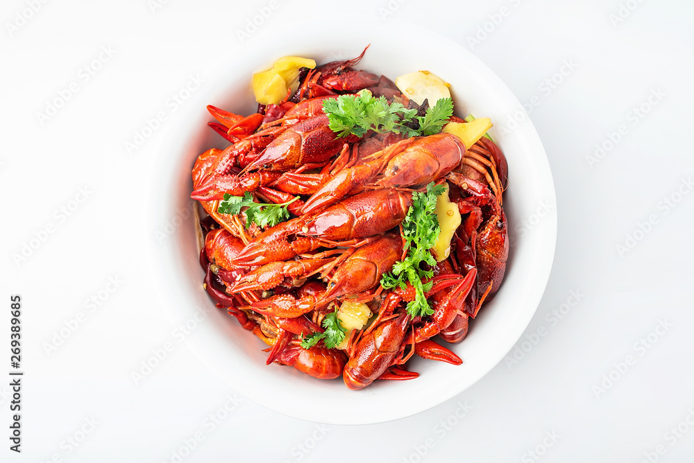 A large bowl of bright red delicious braised crayfish on a white background