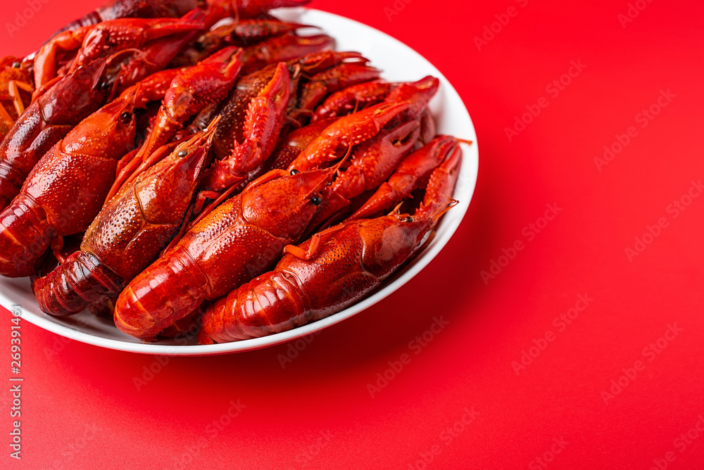 A large bowl of bright red delicious crayfish on a red background A large bowl of bright red delicious crayfish on a red background