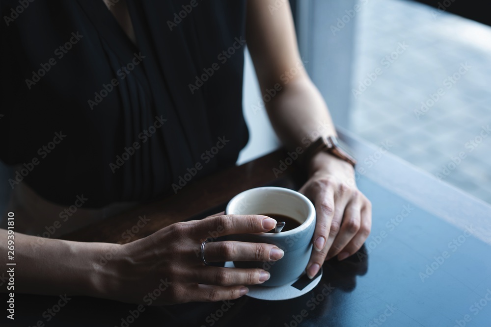 Portrait of gorgeous female drinking tea or coffee and looking with smile out of the coffee shop window while enjoying her leisure time, nice business woman lunch in modern cafe during her work break. Portrait of gorgeous female drinking tea or coffee and looking with smile out of the coffee shop window while enjoying her leisure time, nice business woman lunch in modern cafe during her work break.
