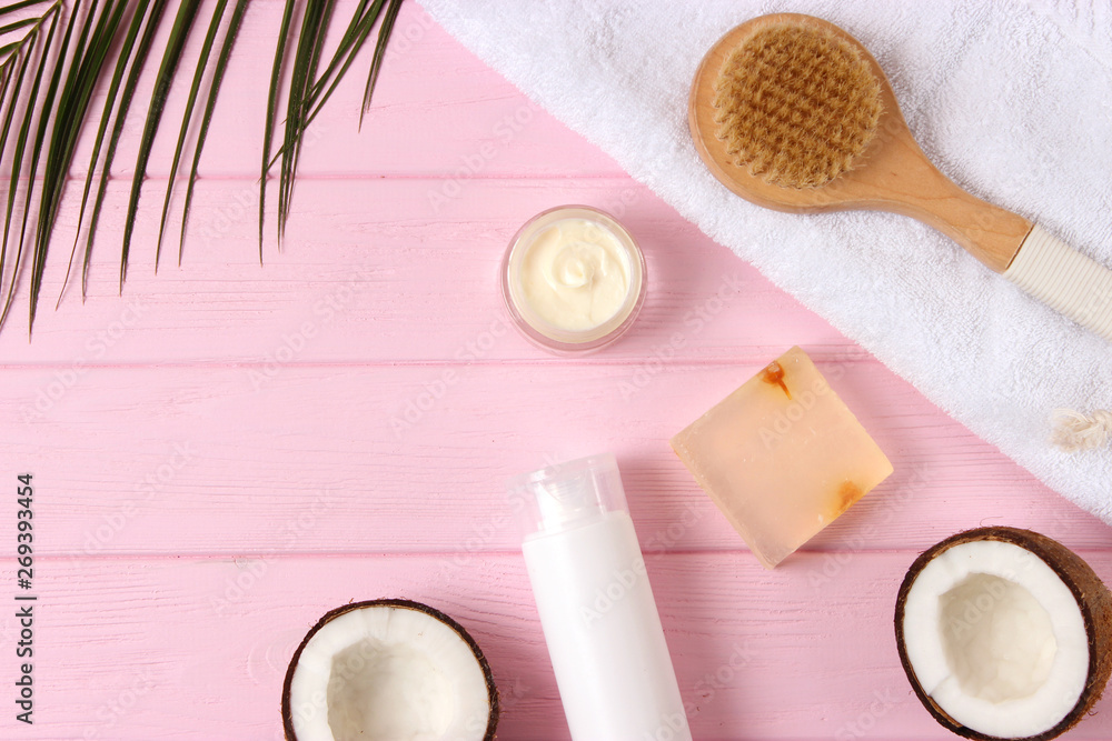 Coconut, tropical leaf and care products on a colored background top view. Cosmetics with coconut extract for hair, body, face. Skin care, skin hydration. flatlay Coconut, tropical leaf and care products on a colored background top view. Cosmetics with coconut extract for hair, body, face. Skin care, skin hydration. flatlay