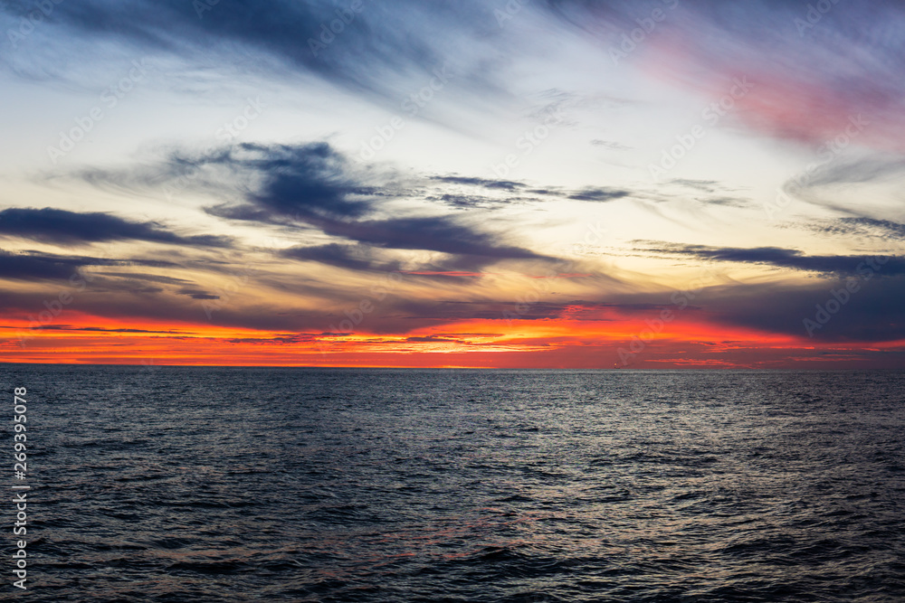 Obraz premium Amazing sunset, sea, the sun with clouds and sun reflection. Open ocean view from boat