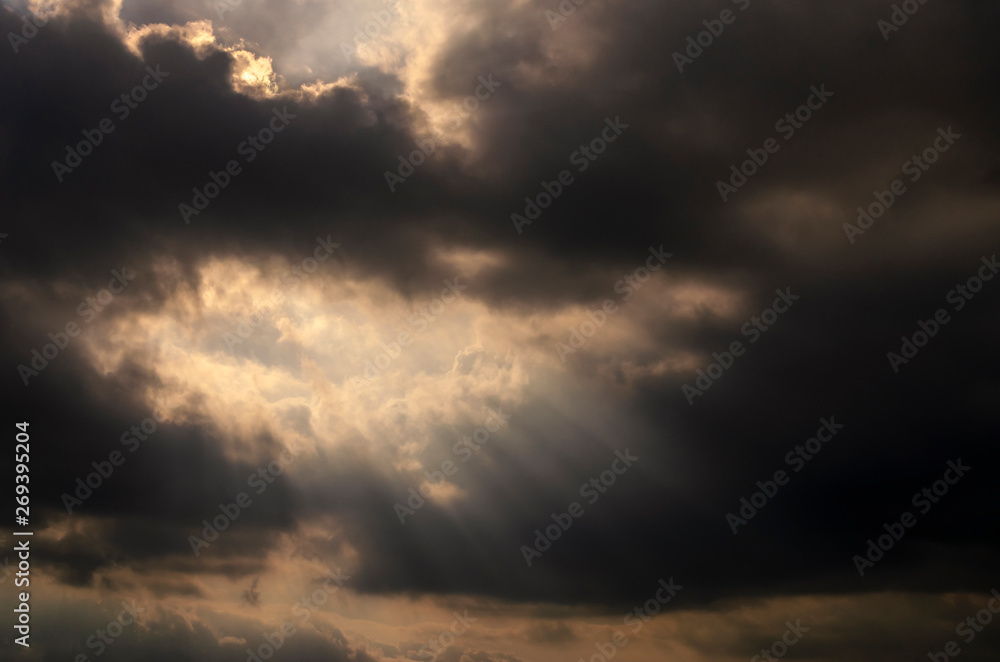 Dramatic dark cloud with sun rays