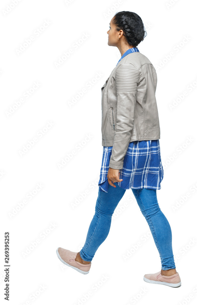 Naklejka premium back view of a young black girl walking in jeans and a checkered