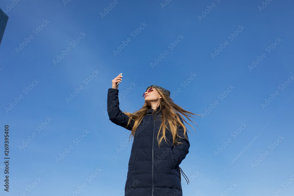 happy woman with arm raised in the air with smartphone happy woman with arm raised in the air with smartphone