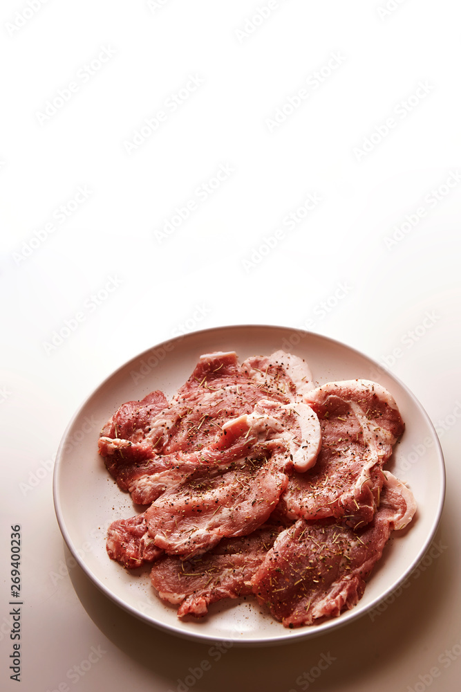 Fresh raw seasoned pork on plate Fresh raw seasoned pork on plate