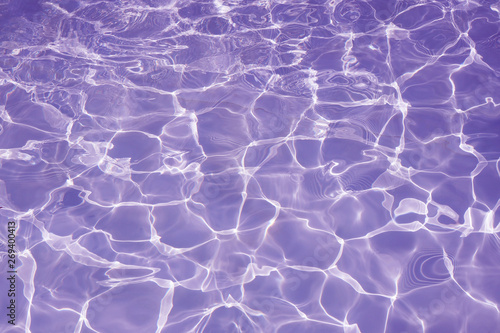 Rippled pattern of clean water in a purple swimming pool for background