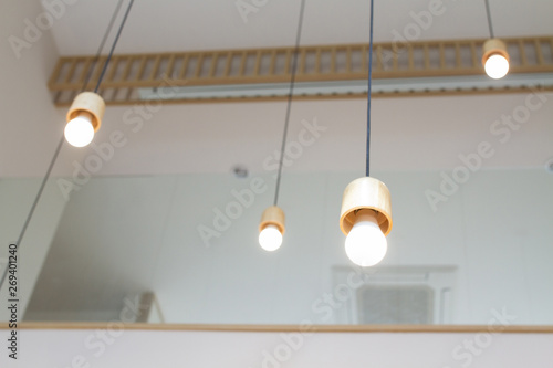 Round warm white LED bulb with wood texture socket lamp hanging from the house ceiling