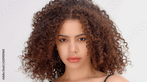 hair blowing closeup portrait of mixed race model with freckles calm watching to the camera