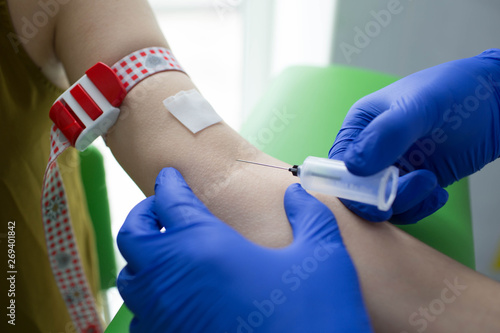 Nurse taking blood sample of patient at clinic close-up © Peakstock
