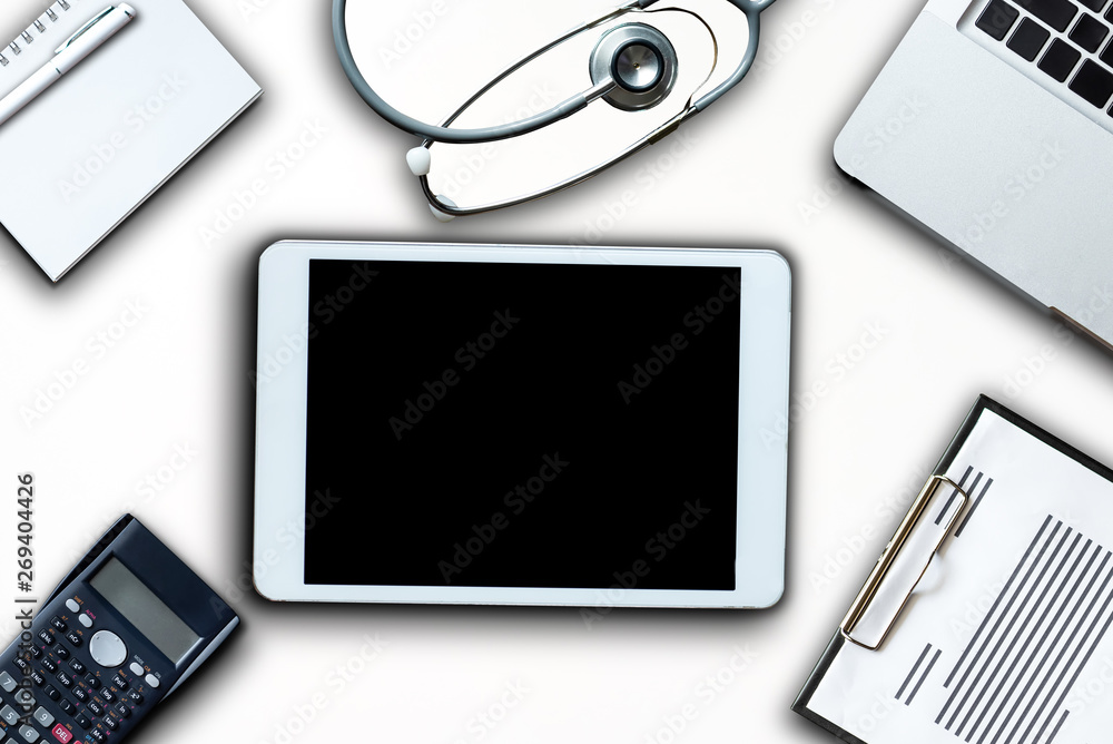 Top view table doctor work desk with laptop, Blood pressure, smartphone, and tablet with clip board and pen Top view table doctor work desk with laptop, Blood pressure, smartphone, and tablet with clip board and pen