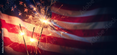 Fotografie, Tablou Vintage Celebration With Sparklers And Defocused American Flag - Independence Da