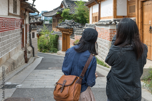 Female tourist taking picture with mobile phone, Bukchon Hanok Village, Seoul, South Korea