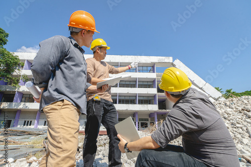 Engineer team and worker checking blueprint for emolition construction plan and inspect at the site.