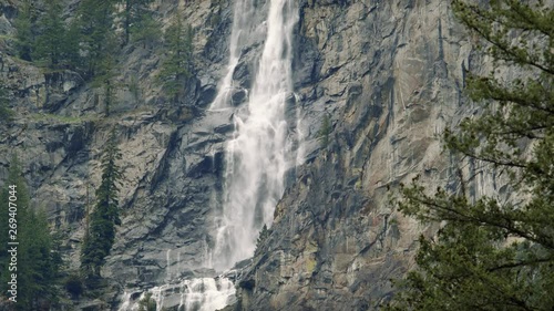 Stunning Waterfall Pan Up Slow Motion Over Rock Cliffs photo