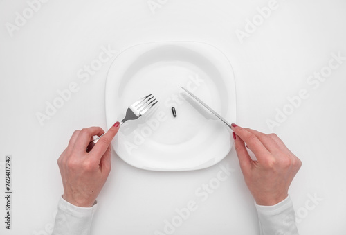 Tablet on a plate. Female hands and drugs on a plate as a concept.