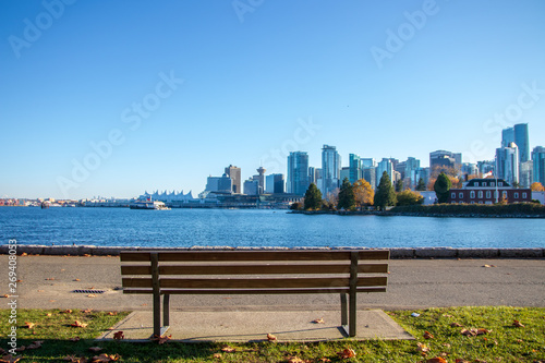 View from bench with Landmark of Vancouver, British Columbia background. View from Stanley Park and seawall in Vancouver, Canada. It is largest urban park with beaches, trails, scenic seawall
