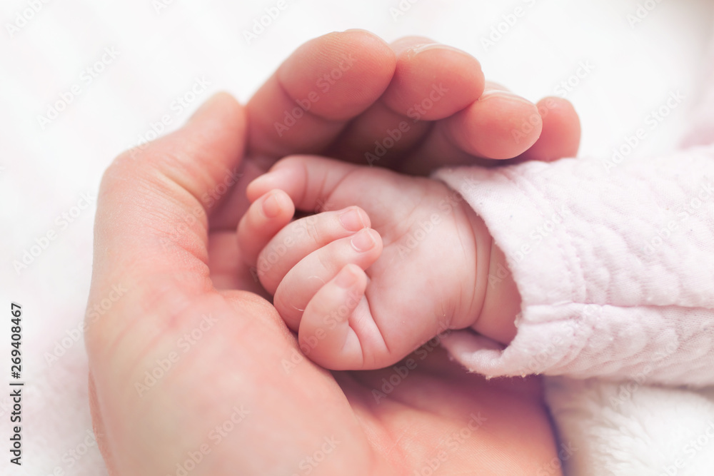 Father holding hand of newborn child