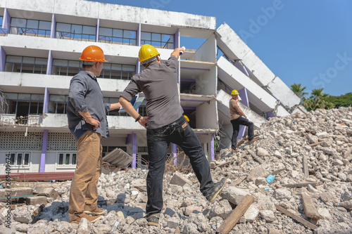 Engineer team and worker checking blueprint for emolition construction plan and inspect at the site.