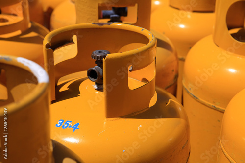 full frame shot of Yellow Propane cooking heating gas Cans cannisters in the sunshine