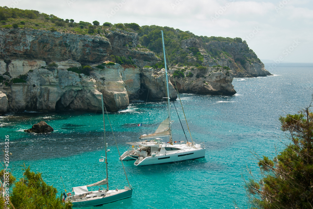 Two sailboats moored in a small bay of Minorca island