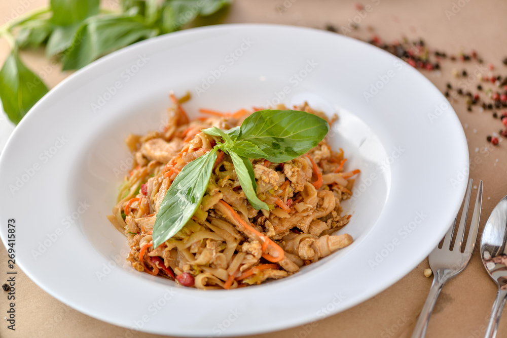 pasta with chicken and vegetables decorated with basil on a white plate pasta with chicken and vegetables decorated with basil on a white plate