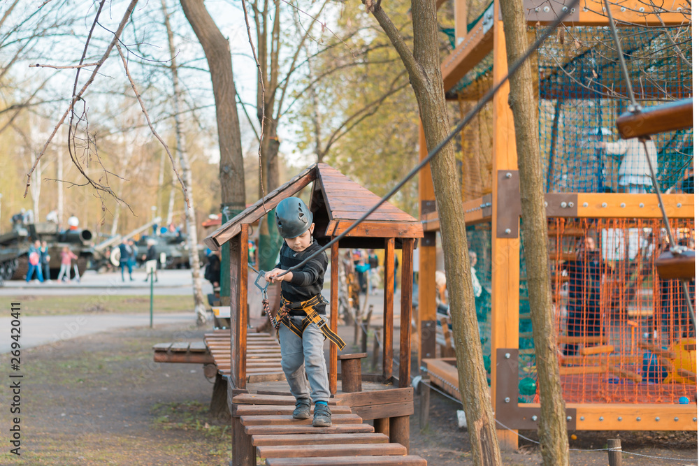 A little boy is passing an obstacle course. Active physical recreation of the child in the fresh air in the park. Training for children.