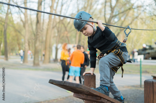 A little boy is passing an obstacle course. Active physical recreation of the child in the fresh air in the park. Training for children.