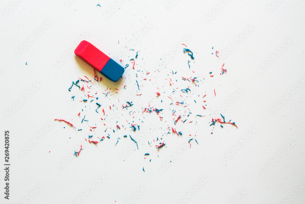 Pink and blue eraser and it's shavings sitting on a clean white sheet of  paper with