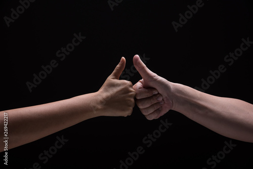 Two hand hit together and show thumb up and touch on black background.