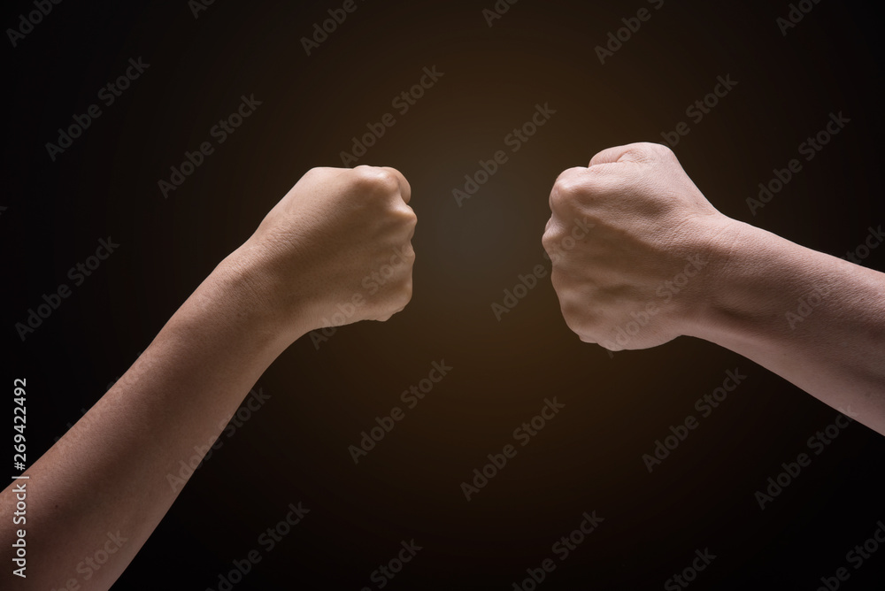 Two fist hand hit together on black background.