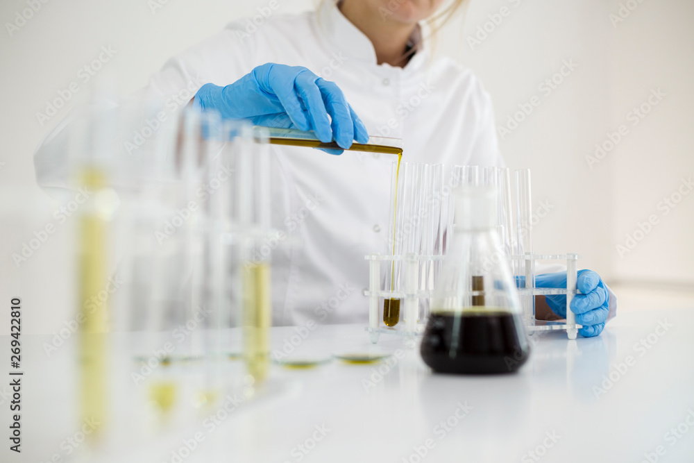 Scientist tearing the CBD oil with a precise dropper from a bowl into a tube Scientist tearing the CBD oil with a precise dropper from a bowl into a tube