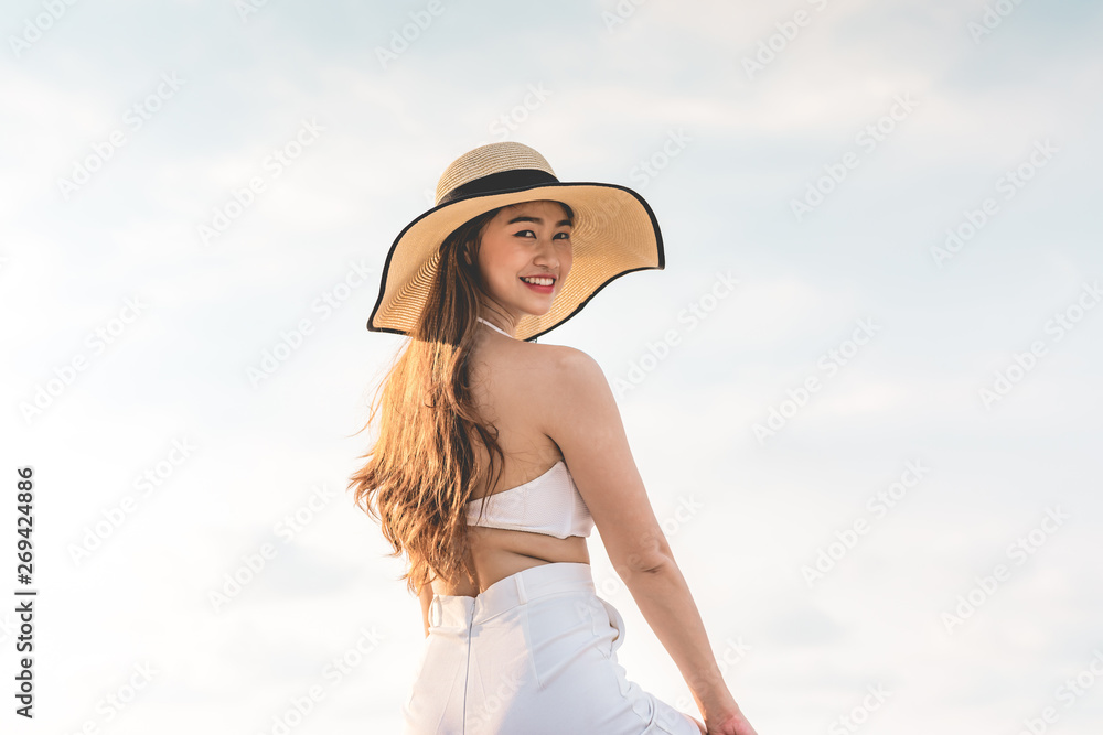 Back of views young woman wearing white dress smile enjoy with summer vacation on pier on beach feeling so happiness and cheerful,Travel in tropical beach in Thailand,vacations and relaxation Concept